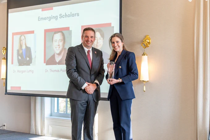 Dr. Morgan Luttig poses with her Emerging Scholar Award and the award presenter.