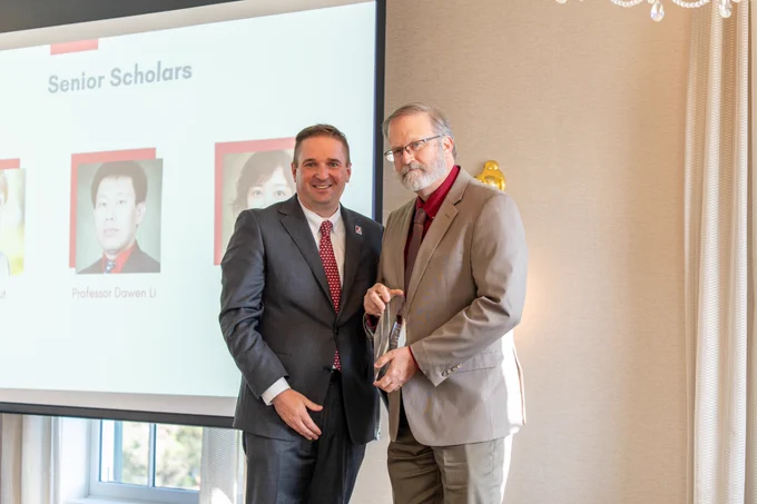 Dr. Steven Trout poses with his Senior Scholar Award and the award presenter.