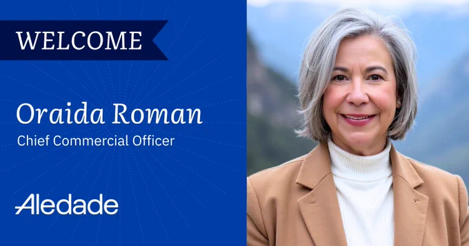 A person with gray hair is smiling in an outdoor setting with mountains in the background. The image includes text: "Welcome Oraida Roman, Chief Commercial Officer, Aledade." The background is blue with a subtle radial pattern.