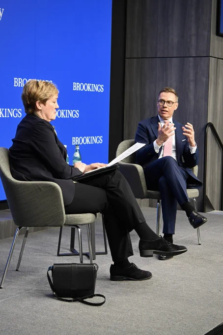President Stubb sitting in a chair speaking with a woman, Stelzenmüller, who is sideways to the camera.