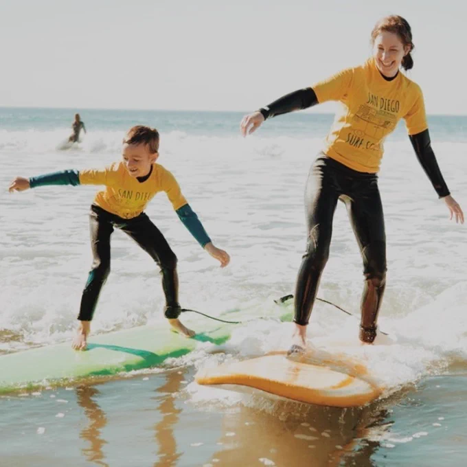 two people standing on surf boards