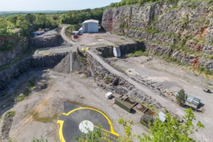 Aerial view of a rocky quarry with a helipad.