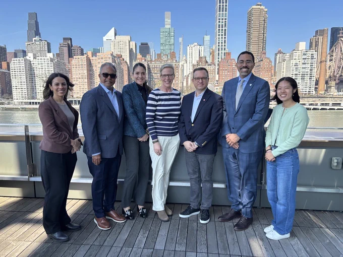 Chancellor King, Cornell Tech leadership, and Cornell Tech students on Roosevelt Island with New York City behind them.