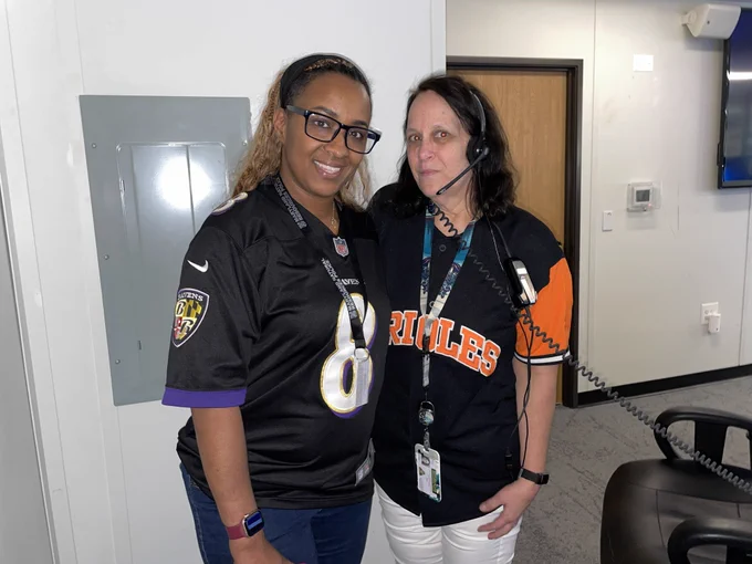 Marquita Curtis and Beth Coleman wear sports jerseys at the communications center for PCO Celebrations