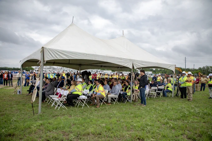 A crowd of people under a white tent listening to a speak at the Walnut Creek Wastewater Treatment plant groundbreaking.