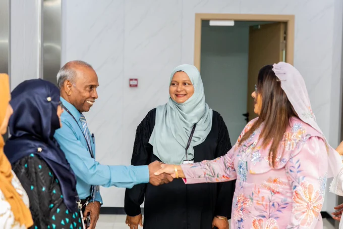 Minister Geela Ali shaking hands with State Minister Ibrahim ismail. He is smiling