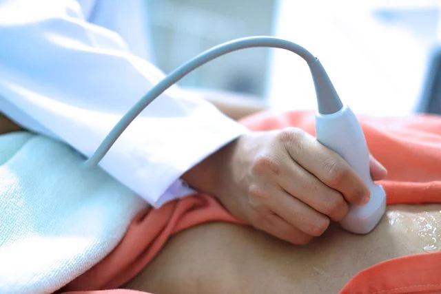 A person is using a medical device on a patient.

