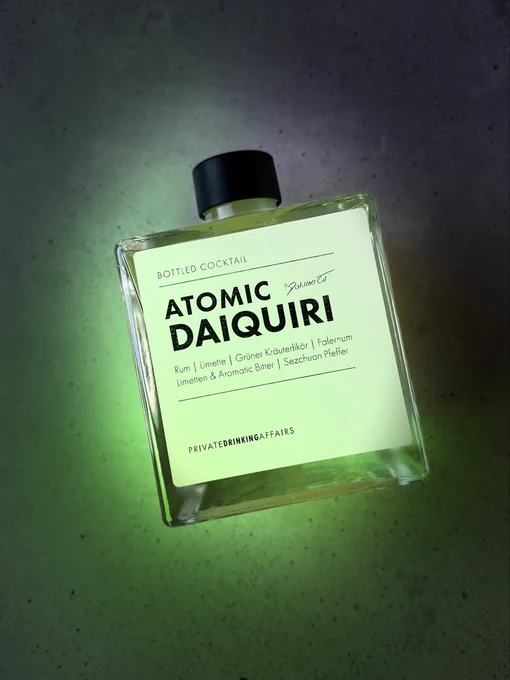 Die Flasche eines fertig abgefüllten Cocktails in Nahaufnahme. Es handelt sich um einen Twist auf den Nuclear Daiquiri namens ATOMIC DAIQUIRI.