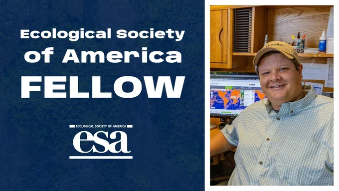 Image of Corey Callaghan smiling and sitting at a desk with computer monitors in the background displaying maps. Text on the left reads "Ecological Society of America FELLOW." The "esa" logo is also visible.