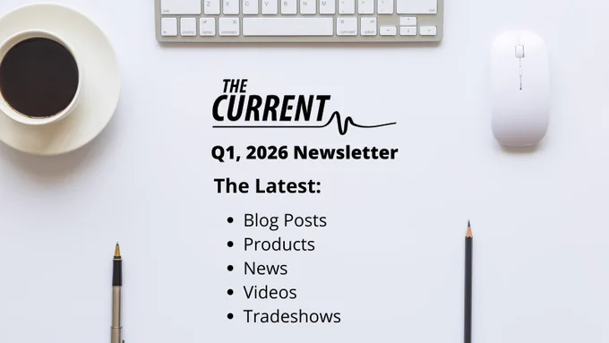 Top-down view of a desk with a coffee cup, keyboard, mouse, and pens. Text reads: THE CURRENT Q1, 2026 Newsletter. The Latest: Blog Posts, Products, News, Videos, Tradeshows.