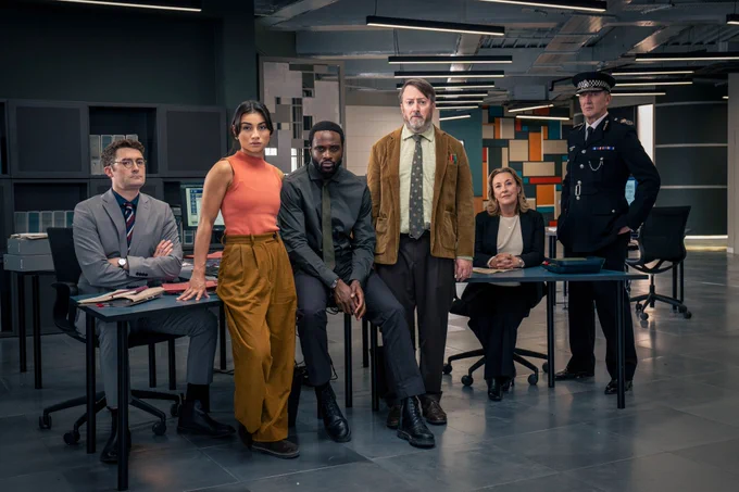 The cast of Ludwig series two stand in an office at a police station. The group shot features featuring DS Ethan Cole; DC Caitlin Sullivan; DI Russell Carter; John ‘Ludwig’ Taylor, DCS Carol Shaw, and Chief Constable Ziegler.