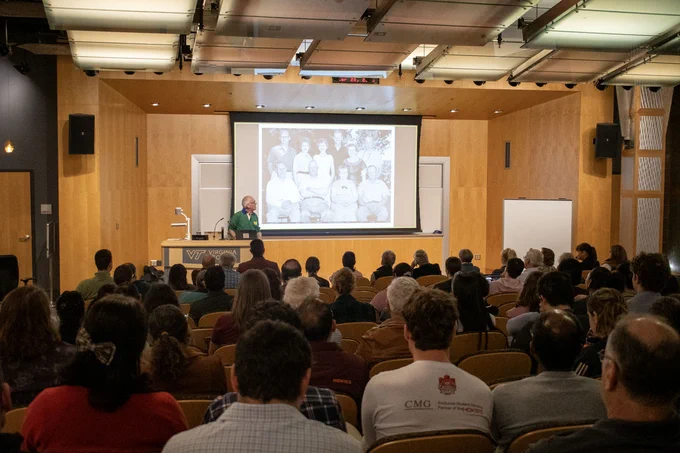 Invited speaker Dr. Eric Holub (University of Warwick, UK) speaking to an audience in the Steger Hall auditorium at the inaugural John McDowell Memorial Lecture.