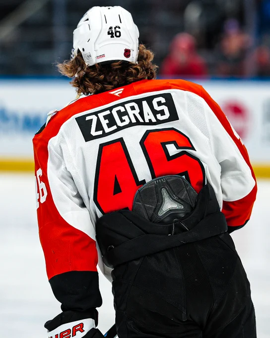 Back view of Trevor Zegras warming up on ice in a Flyers uniform.