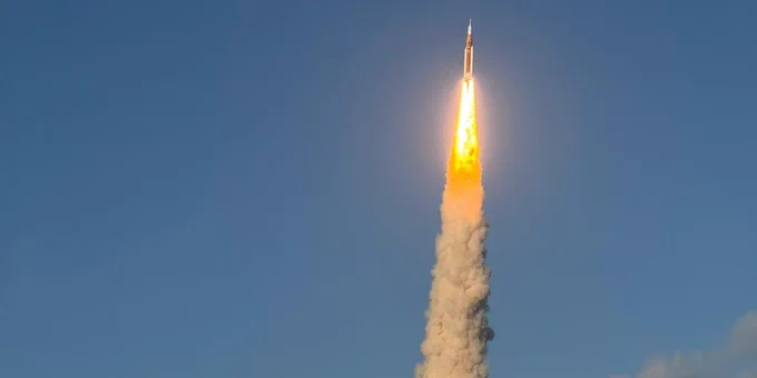 A spaceship taking off with a large exhaust cloud behind it.