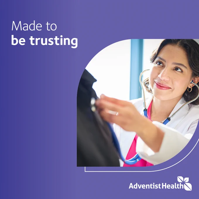 A person wearing a white coat and stethoscope is interacting with another individual, partially visible. The image features the text "Made to be trusting" and the Adventist Health logo.