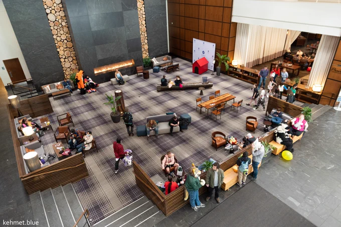 An aerial view of the Hyatt Regency lobby. There are several individuals in suits and out of them talking and milling around. 