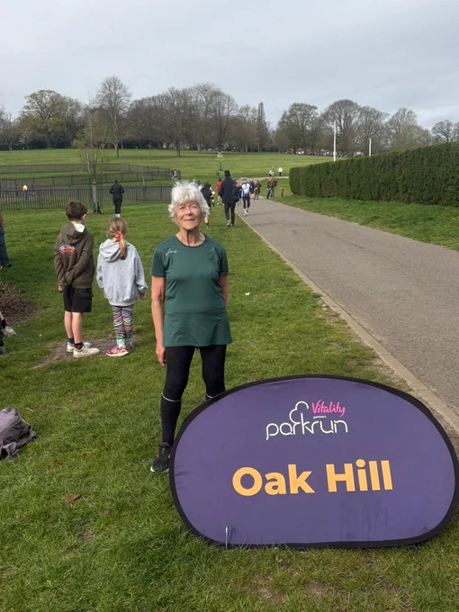 Lesley Jordan standing behind the Oak Hill sign
