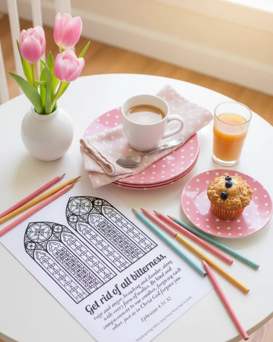 Ephesians 4:31-32 scripture coloring page with stained glass cathedral window design reading "Get rid of all bitterness" displayed on white round table with pink tulips, coffee cup on pink polka dot plates, blueberry muffin, and colorful pencils