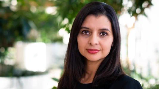 Professional portrait of Ilke Arslan, wearing a black shirt, standing outdoors on Argonne’s campus. 