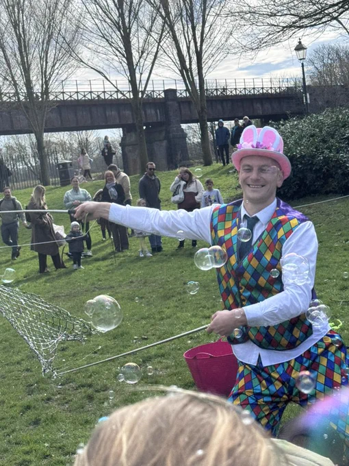 Man blowing large bubbles outdoors