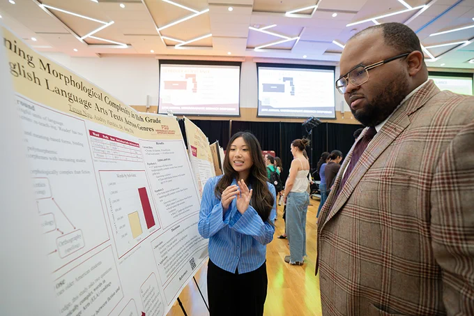 DeOnte Brown, dean of Undergraduate Studies, listens to a student presentation at the symposium.