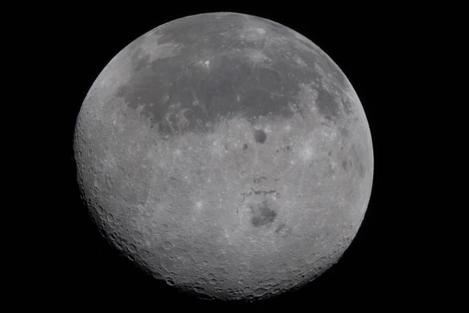 In this view of the Moon, the near side (the hemisphere we see from Earth), is visible at the top half of the Moon disk. It is identifiable by the dark splotches. These are ancient lava flows from a time early in the Moon\u2019s history when it was volcanically active. The large crater that appears below the lava flows, dark in the center, is Orientale basin, a nearly 600-mile-wide crater that straddles the Moon\u2019s near and far sides as is partly visible from Earth on the edge of the Moon. In this image, we have a full view of the crater. Everything below the crater is the far side, the hemisphere we don\u2019t get to see from Earth because the Moon rotates on its axis at the same rate that it orbits round us. Credit: NASA