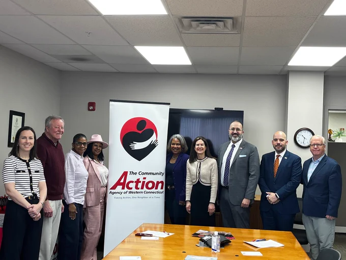 DRS Commissioner Mark Boughton joins fellow state and local officials in a group photo in front of a banner for The Community Action Agency of Western Connecticut in Danbury, CT. 