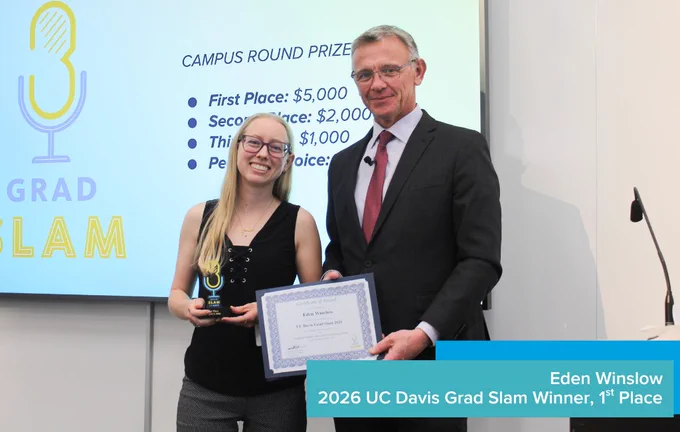 1st place winner Eden Winslow smiling and holding a trophy and certificate next to Dean Jean-Pierre Delplanque.