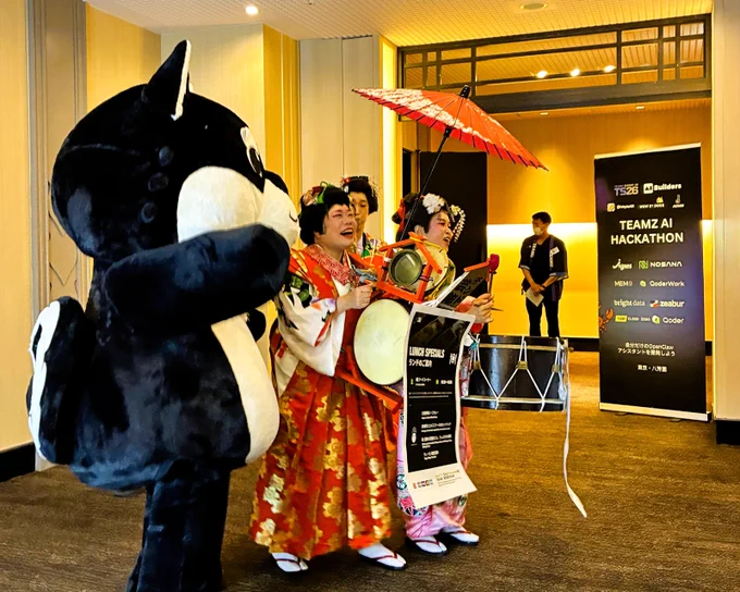 A traditional Japanese street performer in colorful costume, playing drums and a bell to advertise an event (chindon-ya).