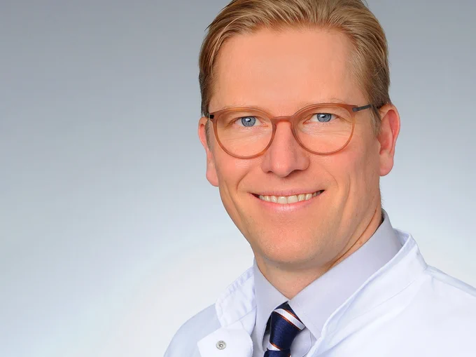 Ein Mann mit blonden Haaren und Brille lächelt in die Kamera. Prof. Dr. Jens Peter Klußmann, Foto: Michael Wodak