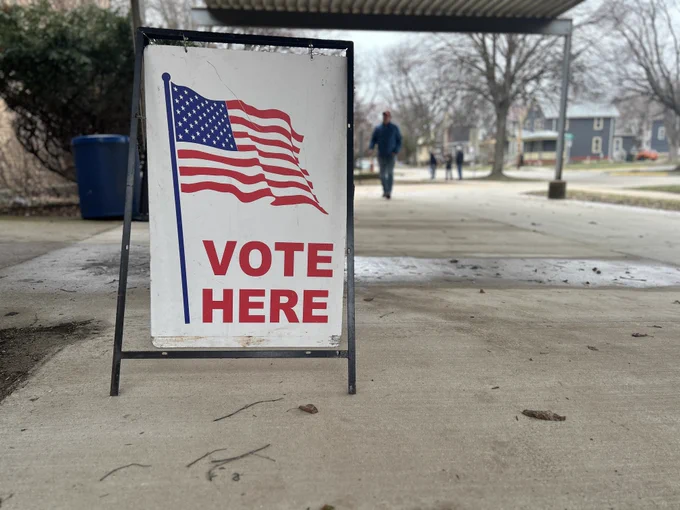Vote Here sign with an American flag located outside a Madison polling place