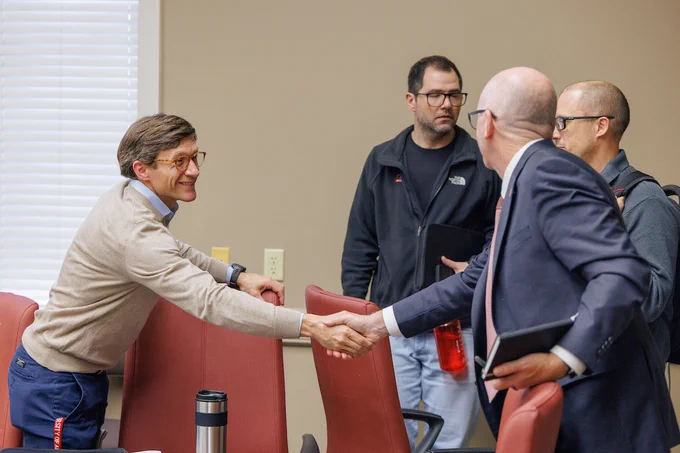 President Mohler shakes hands with an individual in the Faculty Assembly Committee at a recent meeting.