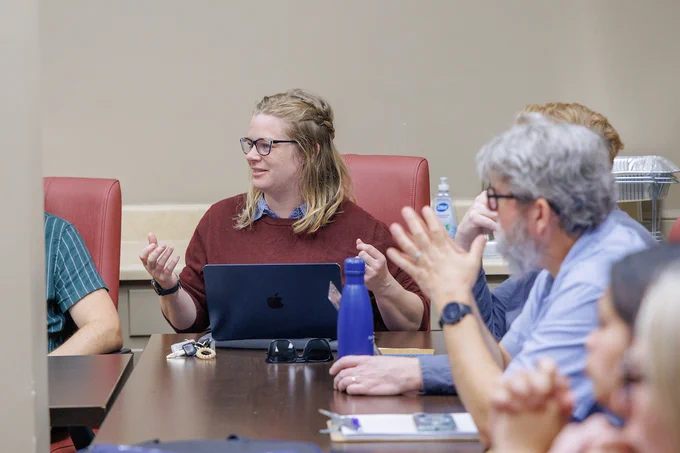 Individuals in the Faculty Assembly Committee, engaged in conversation, at a recent meeting.