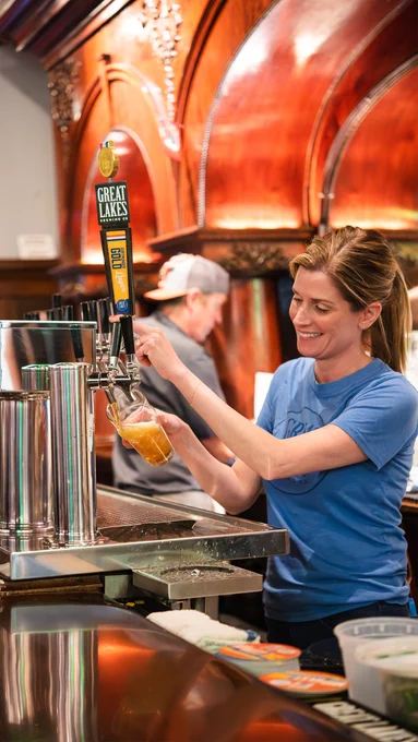 Woman pouring Dortmunder Gold Lager from the Great Lakes Brewing Co. brewpub