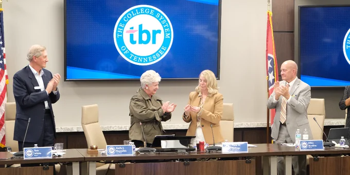 Chancellor Tydings receiving a commemorative coin from fellow board members