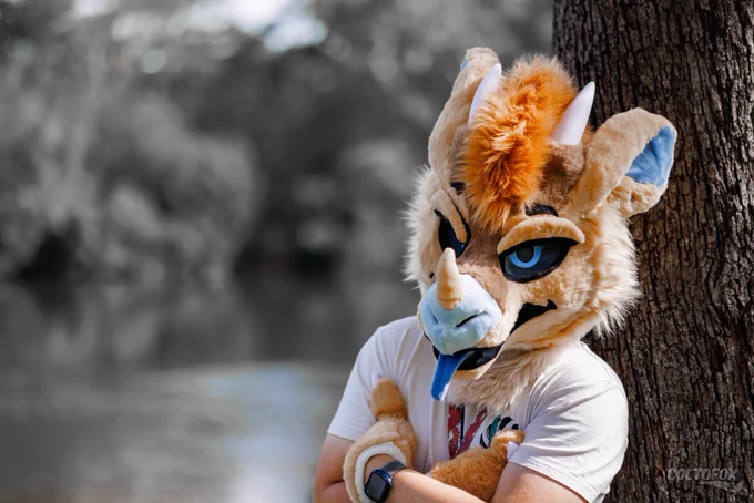 Upper body portrait photo of Aztec (sandwing/icewing hybrid dragon fursuiter) leaning against a tree with his arms crossed. The colour from the background is gone but Aztec appears distinctly in full colour.

Shot on Canon EOS R5 at 85mm f/2.0 ISO100 1/1600s. Taken by Colto Fox at S² Fur Meet (Sydney, NSW) on 28 March 2026.