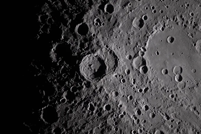 a close-up of the lunar surface lit with dramatic shadows