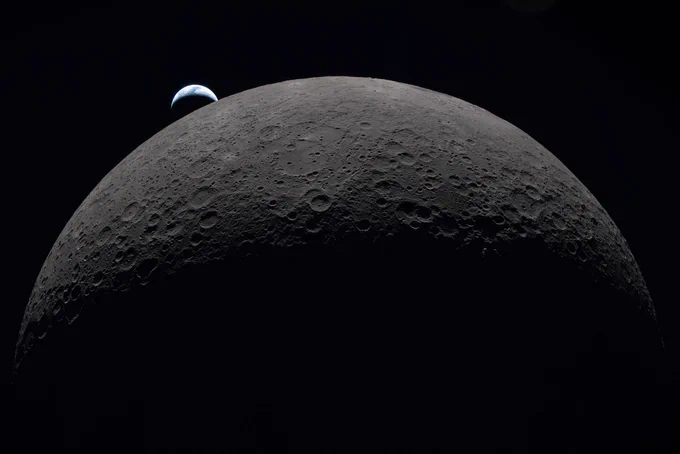 the earth setting behind a giant crescent moon