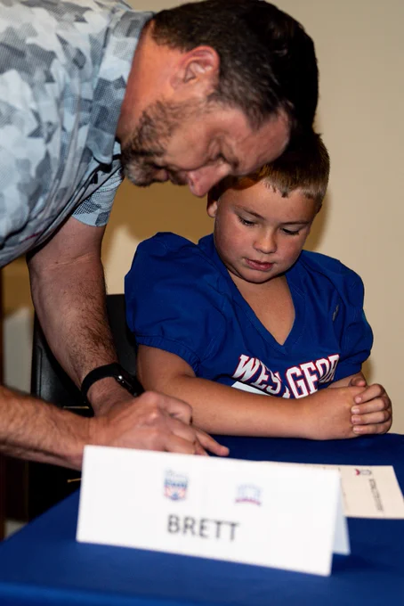 Head football coach Steve Englehart signing a paper with Maddox