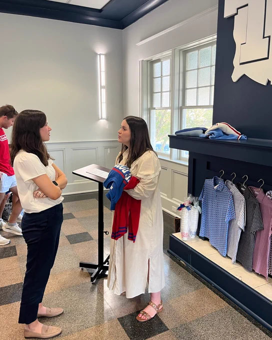 Mallory Patterson talking to another person near a display of shirts