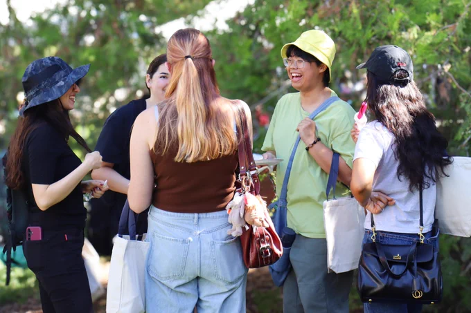 Incoming graduate students smiling and laughing as they enjoy eating popsicles.