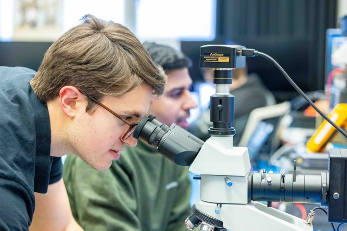 A person uses a microscope 