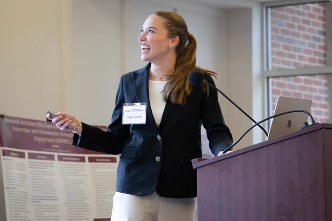 A student smiles during her research presentation.
