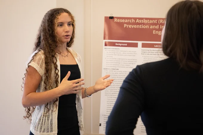 A student presenting her research poster. 