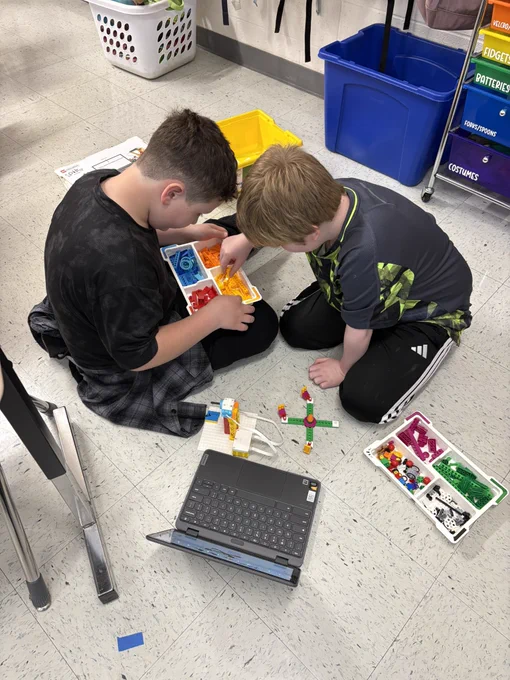 Two boys working to build a spike lego project.