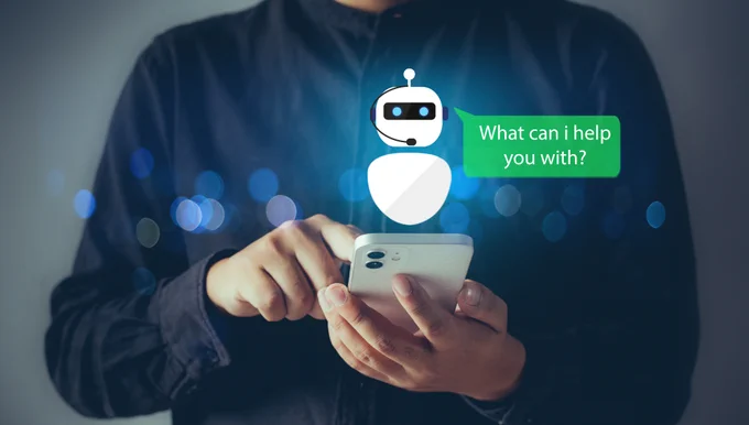 A person holding a smartphone with an illustrated chatbot appearing above the screen. The chatbot has a speech bubble that says, "What can I help you with?