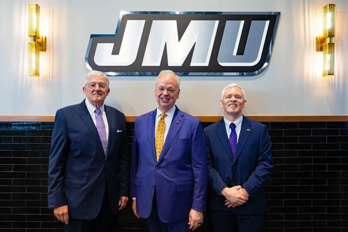 From left to right: President Emeritus Dr. Linwood Rose, President Schmidt and President Emeritus John Alger pose for a photo under the JMU logo.