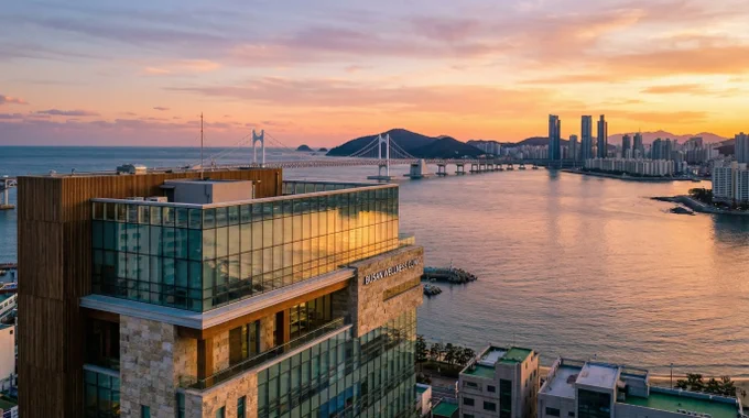 Cinematic Busan coastal skyline at golden hour with modern luxury clinic building