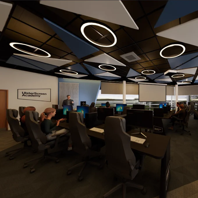 Modern office space with multiple employees working at computer desks under geometric ceiling lights.