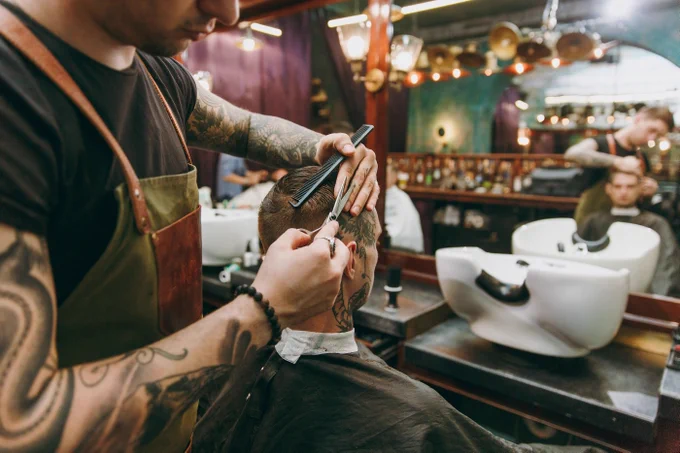 Barber cutting a client’s hair in a local barbershop